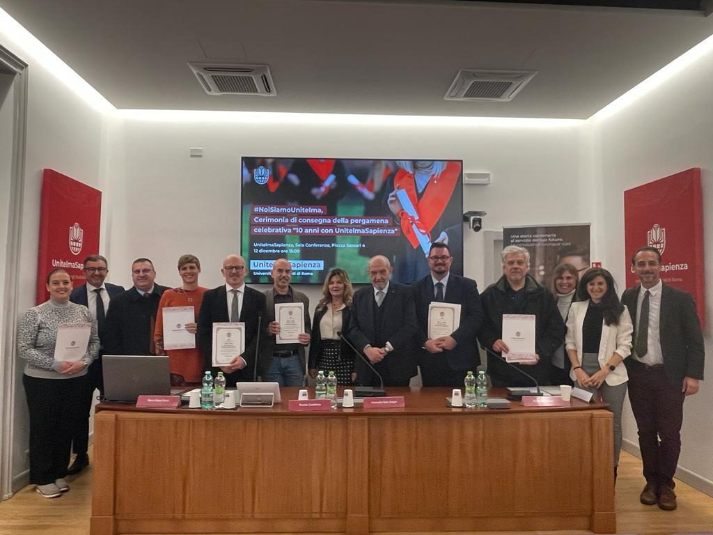 Gli studenti vengono premiati dal rettore con la pergamena celebrativa dei 10 anni con unitelmasapienza